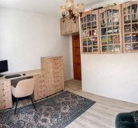 A study in a family house with a wooden decor floor and a bookshelf.