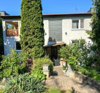 A family house in Sady nad Torysou with a well-maintained garden and pathway, surrounded by greenery.