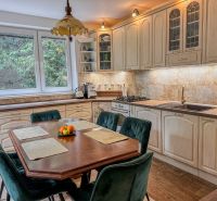 A kitchen in a family house with a wooden decor floor and a dining table.