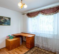 Interior of a family house with a wooden table next to the window and decoration on the wall.