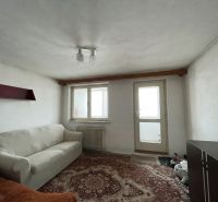 Living room with a sofa and a carpet in a family house, with white walls and doors.
