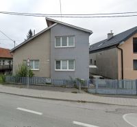 A family house on a street in Likavka with a fence and a sloped roof.