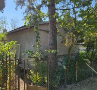 A cottage on Popradská Street in Košice West surrounded by greenery and trees.