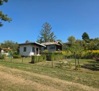 A cottage on Popradská Street in Košice West surrounded by greenery and a grassy plot.