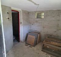 A cabin with unfinished walls and tiles on the floor with a wood design.