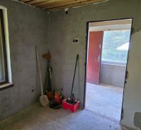 The interior of a cabin with unfinished walls and work tools.