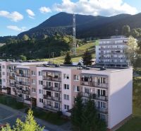 Apartment buildings on Papiernícka Street in Ružomberok with a view of the surrounding landscape.