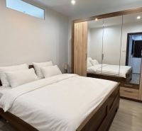 Bedroom with a mirrored wardrobe, wooden furniture, and a white bed in a 3-room apartment.