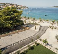 A view of a seaside recreational apartment in Sevid with trees and parking by the beach.