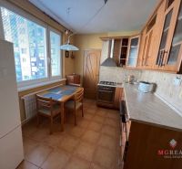 A kitchen in a 3-room apartment with a wooden decor and a dining table.