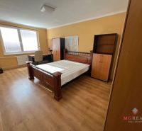 A bedroom with wooden furniture and a floor with a wood decor in a 3-room apartment.