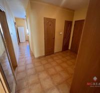 A hallway in a 3-room apartment with light-colored doors and tiled flooring.