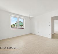 A bright room with a large window and wood-patterned flooring in a family house.