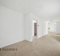 A hallway in a family house with a wooden decor floor and white walls.