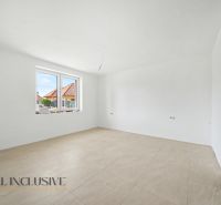 Spacious room in a family house with white walls and light tiles.