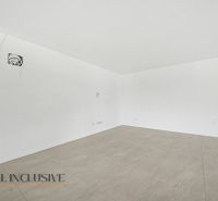 An empty room with white walls and a floor with a wooden decor in a family house.