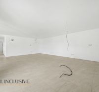 A spacious room with white walls and a floor with a wooden decor in a family house.