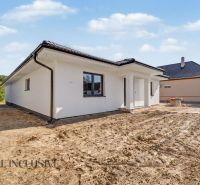 Tomášik's family house with light plaster and a sloped roof, surroundings without landscaping.
