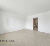A spacious room with white walls and a light floor in a family house.