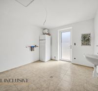 A view of the utility room in a family house with tiles and a sink.