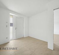 Entrance hall in a family house with white walls and wood-patterned tiles.