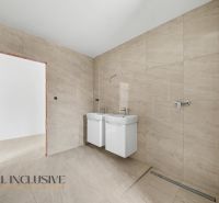 A bathroom in a family house with a double sink and beige tiles.