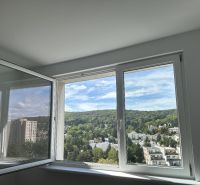A view from the window overlooking greenery and buildings in a 2-room apartment.