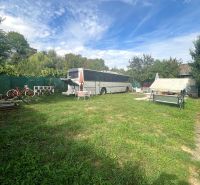 The garden at the cottage in Bánovce nad Bebravou with a bus, bicycle, and swing.