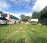 A garden with a bus converted into a cabin in Bánovce nad Bebravou, surrounded by greenery.