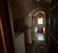 Interior of a cabin with two beds and a window, floor with wooden decor.
