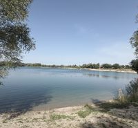 A lake in Bodíky with a shore, trees, and a boat, ideal for relaxing by the water.