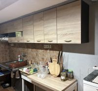 A kitchen in a cottage with a wood-decor floor and wooden cabinets.