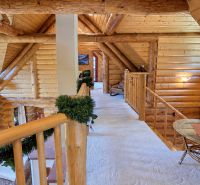Wooden ceilings and cosmetically decorated railings create a cozy atmosphere in the cabin.