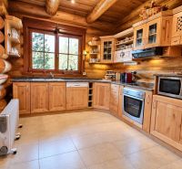 Wooden kitchen with natural light, windows overlooking the forest, compact equipment.