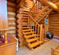 Interior of a cabin with wooden stairs and wooden decor.