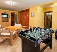 Interior of a cabin with a foosball table, sauna, and comfortable seating for relaxation.