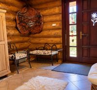 The interior of the cabin with wooden furniture, a soft carpet, and carved decorations on the doors.