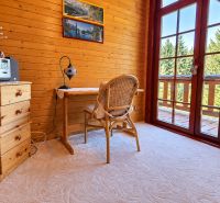 Massive wooden cabinet and table with a lamp in the cabin, view of the forest.