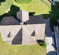Aerial view of a cottage in Banská Bystrica with surrounding greenery and lawn.
