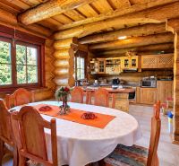 Interior of a cottage with a wooden table and a kitchenette, floor with wooden decor.