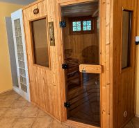 A sauna in a cottage with ceramic tiles and a wooden structure.