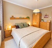Bedroom in a 3-room apartment with wooden furniture and decorative accessories.