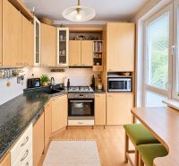 A kitchen with wooden decor, a kitchen unit, a stove, and a large window in a 3-room apartment.
