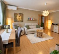 Living room of a 3-room apartment with an elegant wooden decor floor and comfortable furnishings.