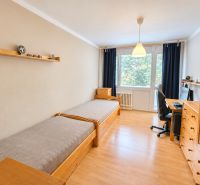 A room with beds, a work desk, and a floor with wooden decor in a 3-room apartment.