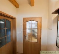 Interior doors with glass panels and wooden beams on the ceiling in the cottage.