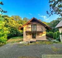 A cottage in Ružiná surrounded by greenery, with a balcony and air conditioning.