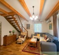Living room in a cottage with wood-decor flooring and comfortable seating.