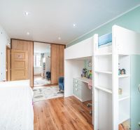 Children's room with a bunk bed, a desk, and a floor with a wooden decor in a two-room apartment.