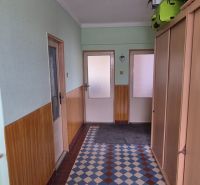 Hallway in a family house with an entrance door and a built-in wardrobe.